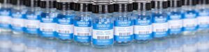 Five blue bottles filled with lab-produced vaccines | Wake Clinical Research