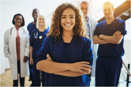 pictured: a group of health care workers stand and smaile